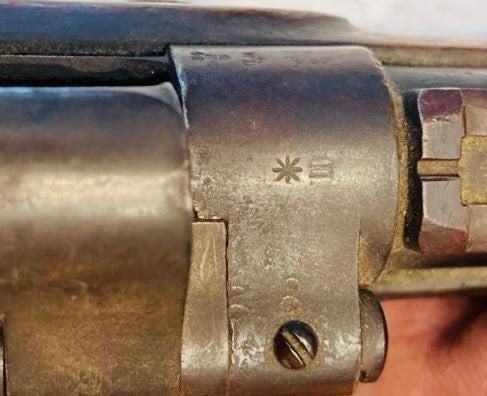 Close-up of engraved proof marks on a weathered rifle receiver